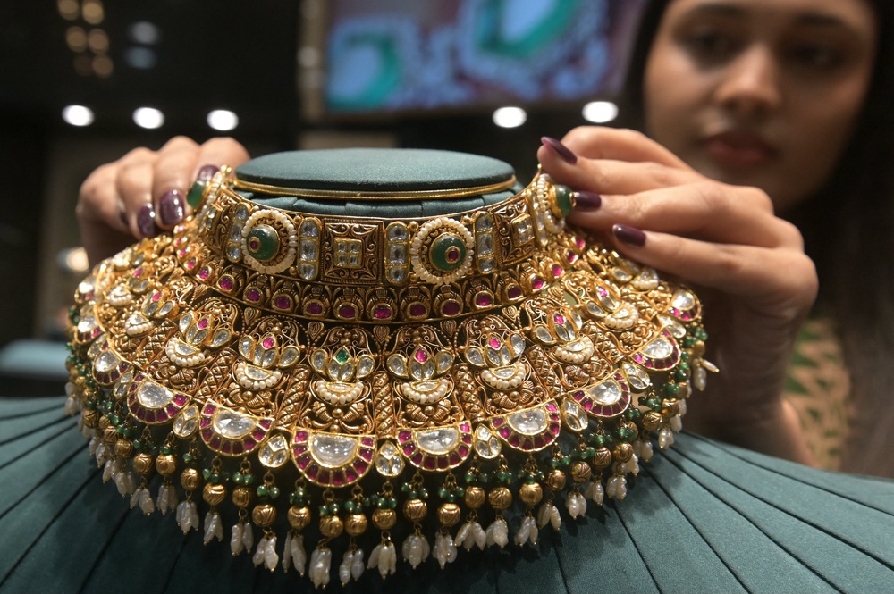 An employee displays a gold necklace at a jewellery store in Amritsar on 12 May 2026 (AFP/Getty)