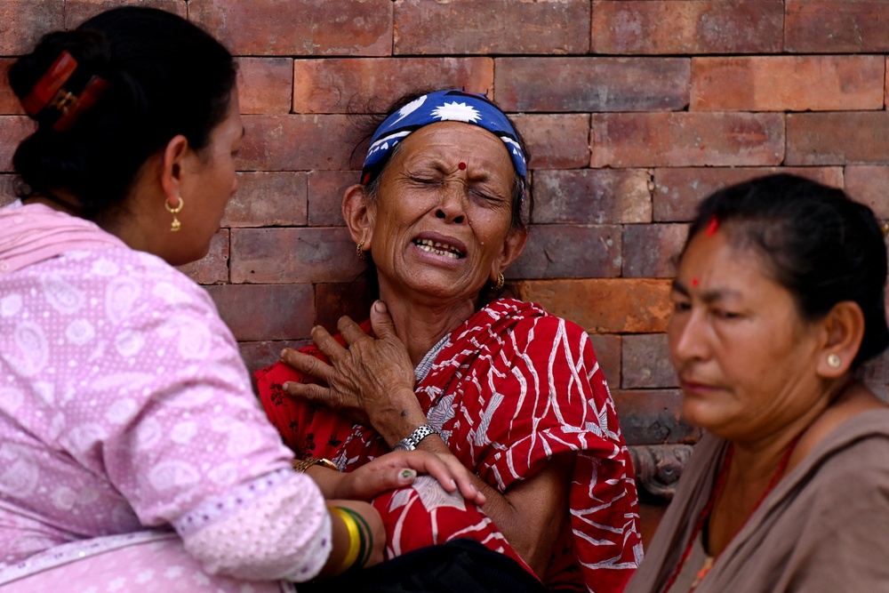 Relatives mourn during symbolic funerals held for flood victims still reported missing as they cremate Kush grass effigies in accordance with Nepali Hindu rites at the Pashupatinath temple in Kathmandu on 2 September 2026 (AFP/Getty)