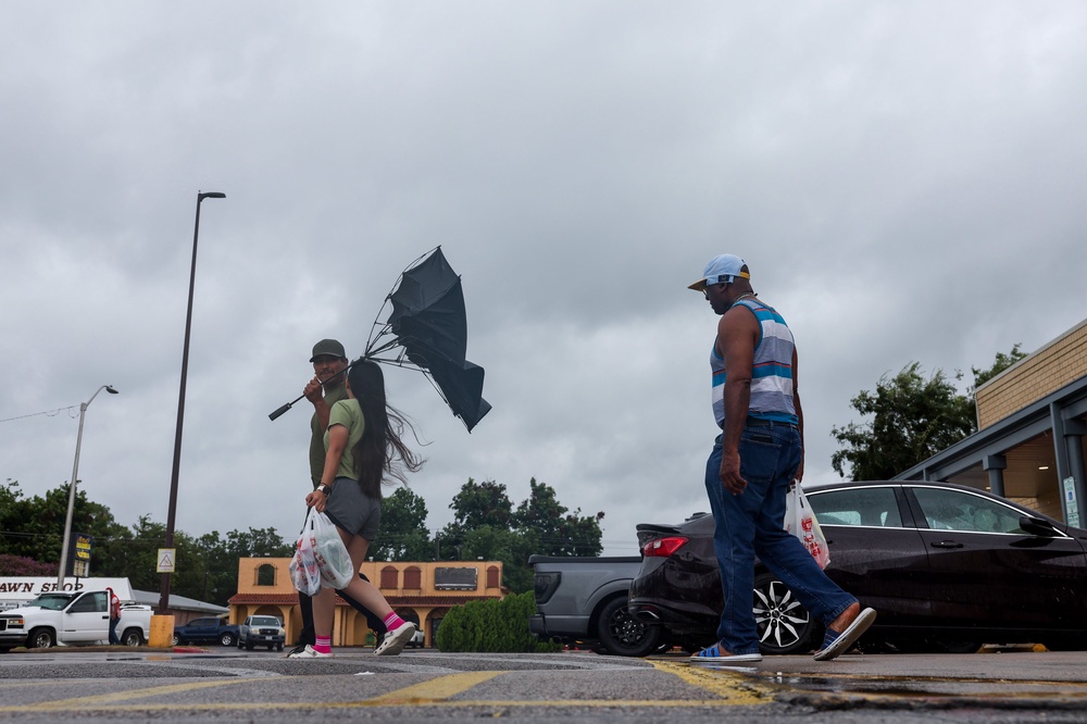 A man tries to hold onto an umbrella as he walks out of a grocery storm on Tuesday in Port Arthur, Texas. Edouard made landfall along the Texas-Louisiana border on Tuesday afternoon (Getty)