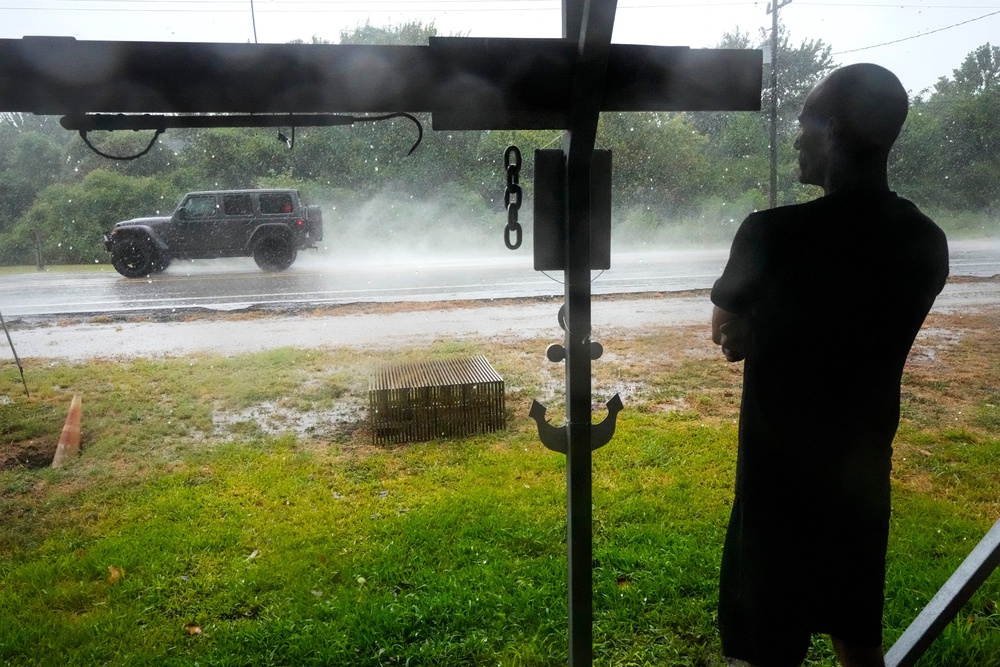 A man watches flooding rain from Edouard fall in High Island, Texas, on Tuesday. Water rescues are underway in the area as the depression continues to dump inches of rain (AP)