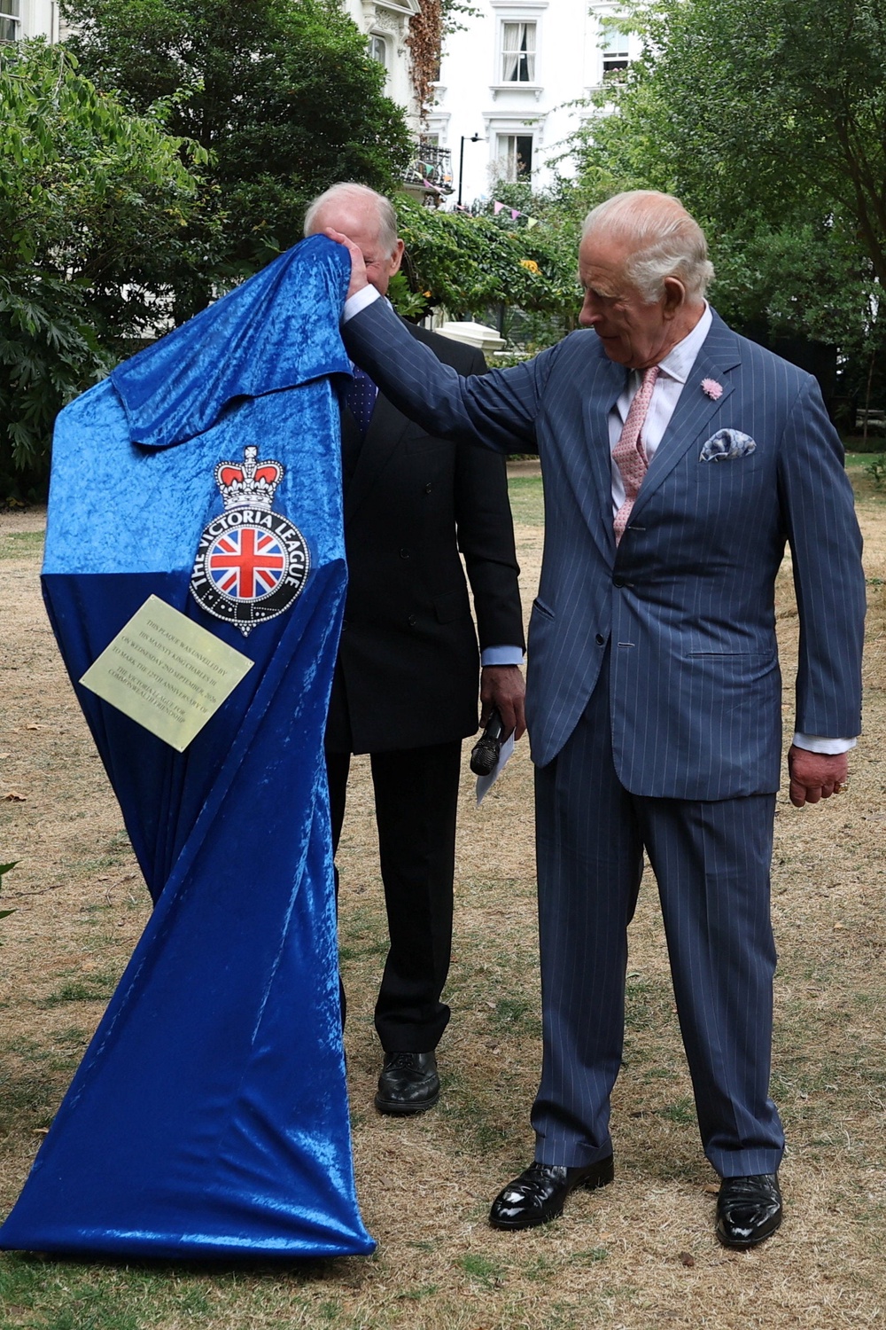 A commemorative plaque falls during an official unveiling by the King (Toby Melville/PA) (PA Wire)