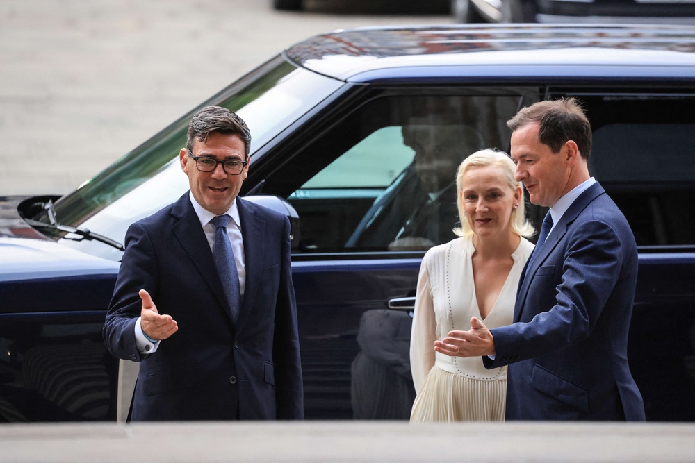 Andy Burnham, left, and his wife Marie-France van Heel, centre, are greeted by British Museum chair George Osborne, right (AFP/Getty)
