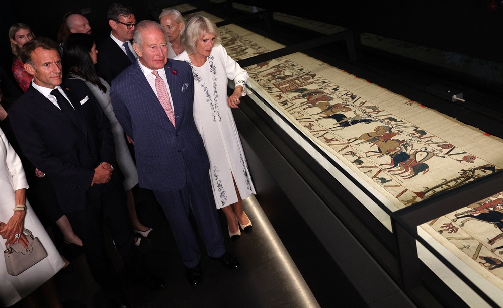 King Charles III and Queen Camilla alongside Emmanuel Macron view a section of the Bayeux Tapestry (AFP/Getty)
