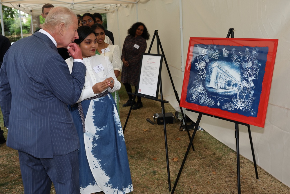 Charles speaks with Commonwealth student Ruwanthi Gajadeera as she presents him with a painting of the Victoria League headquarters (Toby Melville/PA) (PA Wire)