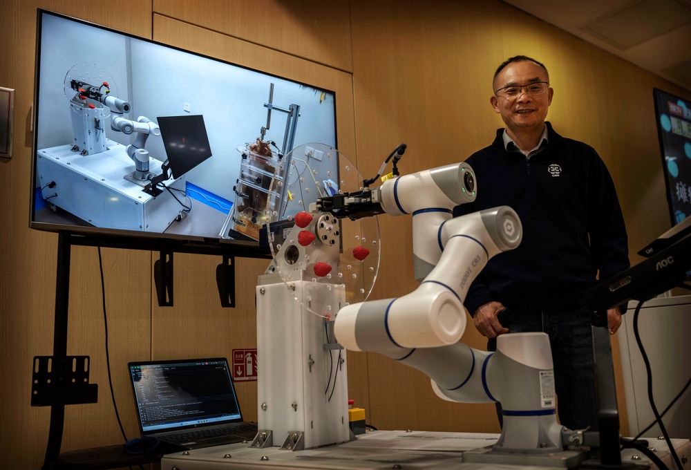 Chinese Institute for Brain Research Director Dr. Luo Minmin stands next to a display demonstrating the Beinao-2, an invasive brain-computer interface system, as a screen shows it being used during animal testing on a monkey, at a press briefing on 19 March, 2026 in Beijing, China (Getty)