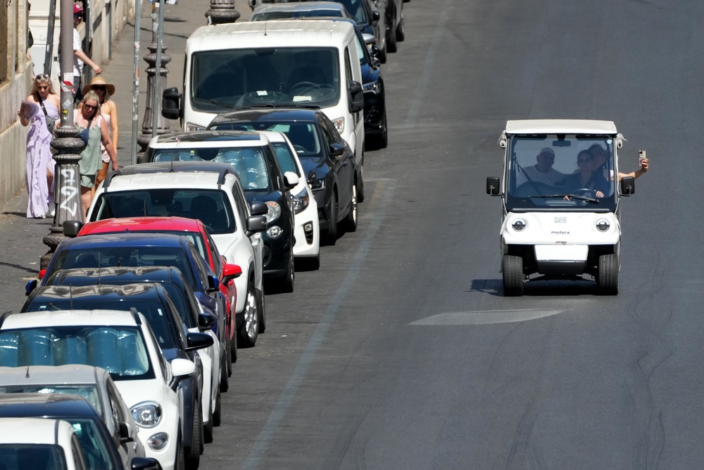 A golf cart carrying tourists travels past parked cars in Rome, Tuesday, Aug. 18, 2026 (AP Photo/Gregorio Borgia) (Copyright 2026. The Associated Press. All rights reserved)