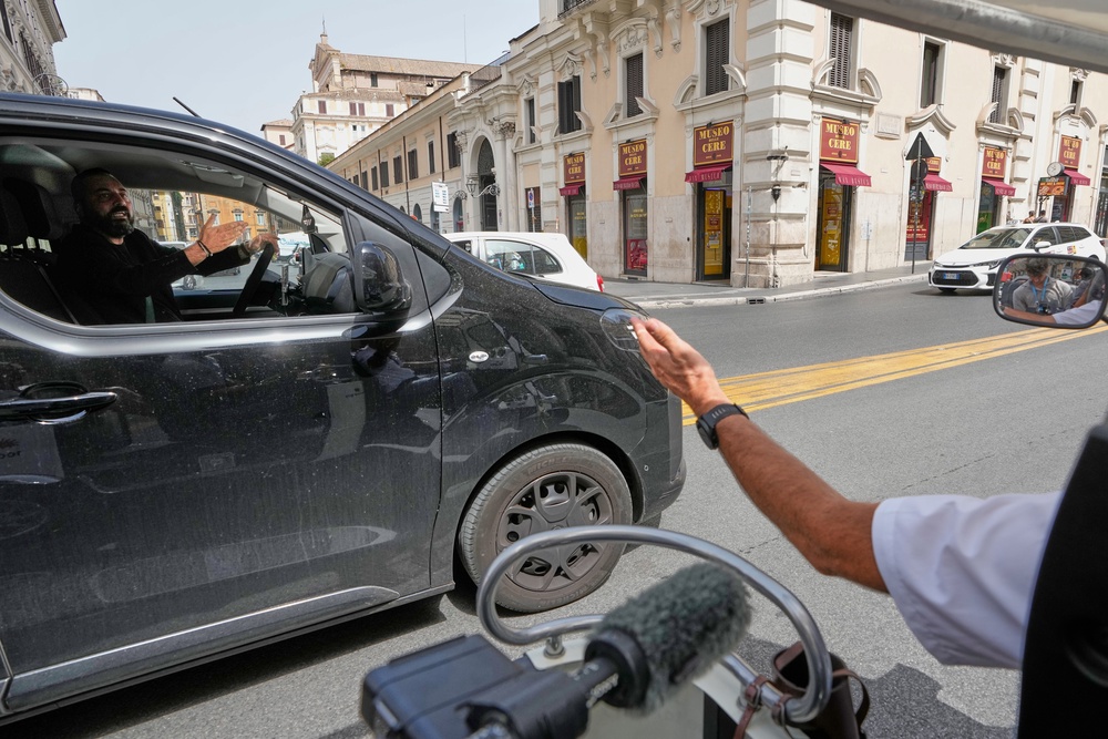 Pascal Duijnhoven, right, argues with a private-hire driver as he drives his golf cart in downtown Rome, Thursday, Aug. 27, 2026, amid growing debate over the vehicles’ role in congestion and overtourism. (AP Photo/Gregorio Borgia) (Copyright 2026. The Associated Press. All rights reserved)