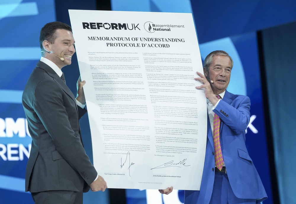 Nigel Farage and Jordan Bardella hold up a signed memorandum of understanding (Stefan Rousseau/PA) (PA Wire)