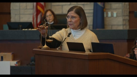 Dana Chandler uses the scales of justice while delivering closing arguments on March 7, 2025, to defend herself at her third double-murder trial in the 2002 slayings of her ex-husband Mike Sisco and his girlfriend, Karen Harkness (HBO)
