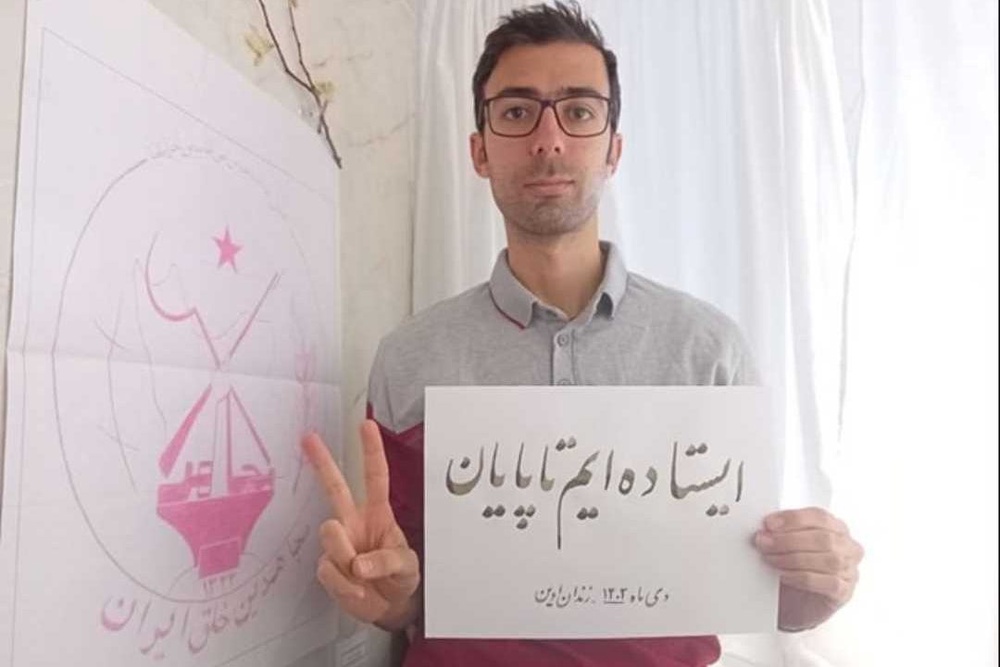 Another image of Vahid Baniamerian from inside prison, holding a sign with a similar message: 'We will stand until the very end' (Handout)