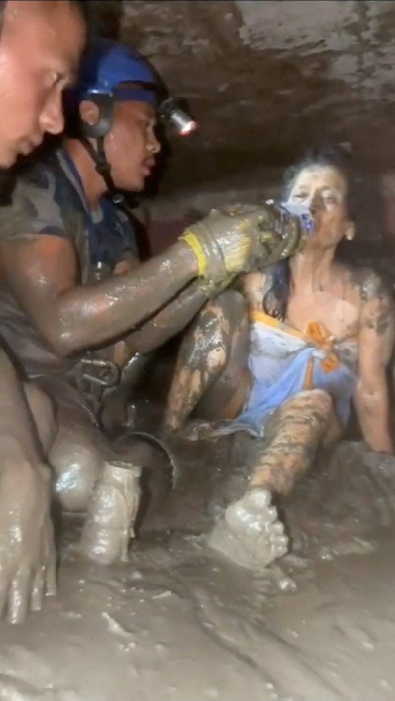 Rescuers give water to a woman as she is rescued from a house, following deadly flash floods and a mudslide, at a location given as Nuwakot, Nepal (Reuters)