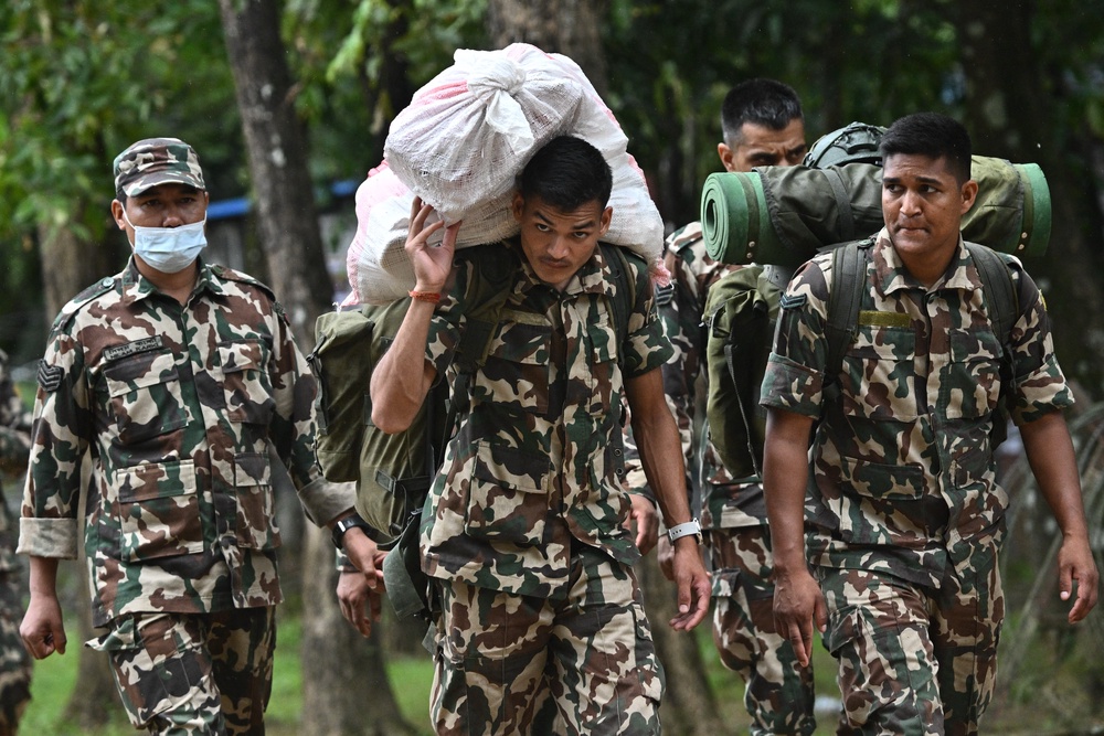 Army personnel carry relief supplies for flash flood victims inside a temporary relief camp at Trishuli Bazar in Nepal's Nuwakot district (AFP/Getty)