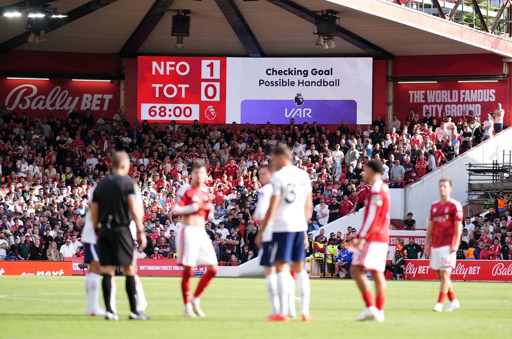Players wait during a VAR check after Nottingham Forest's Neco Williams scored, only to be ruled out for handball (PA)