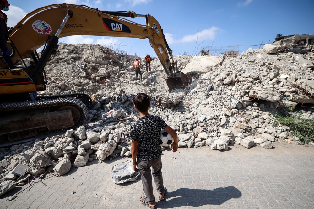 A young boy looks on as Civil Defence personnel dig through the rubble of Al-Muhandisin Tower looking for human remains, in the Nuseirat camp for refugees in the central Gaza Strip on 5 September 2026 (AFP/Getty)