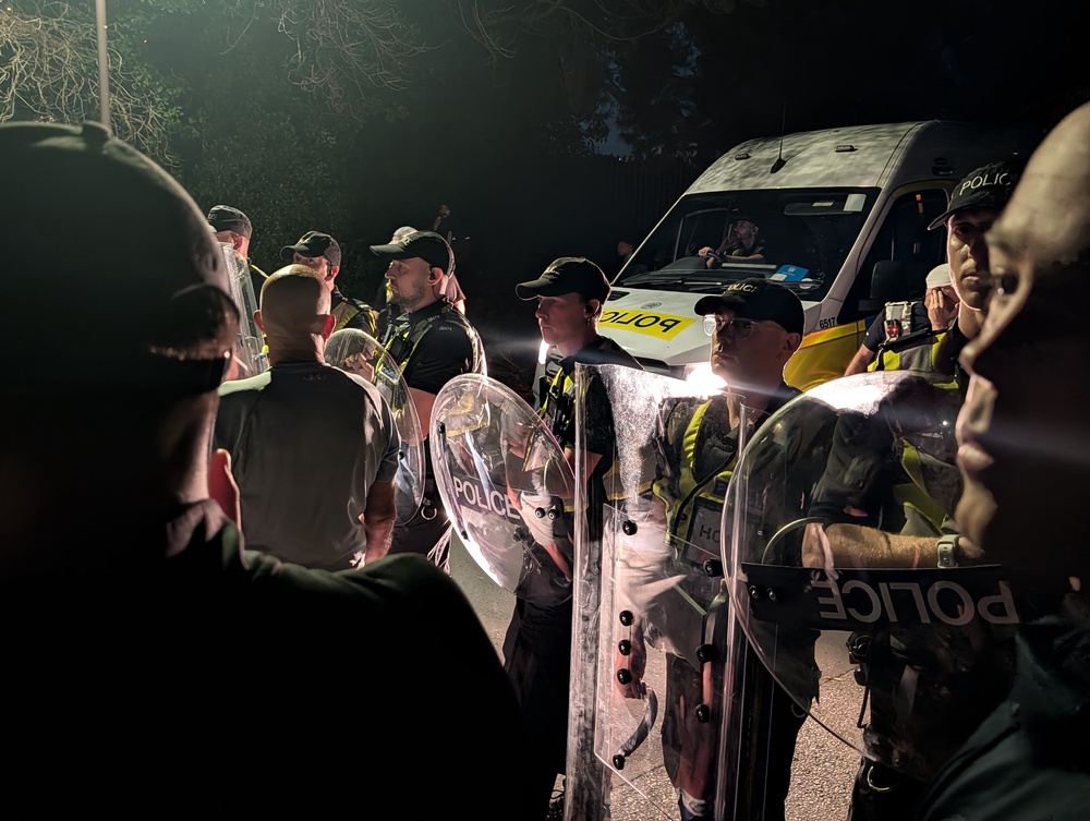 Police officers at the scene near Eastney Beach, Portsmouth, where protesters have gathered, after a small boat thought to be containing asylum seekers and heading towards the coast sparked a major response with a helicopter, aeroplane and lifeboats sent to the scene. (PA)