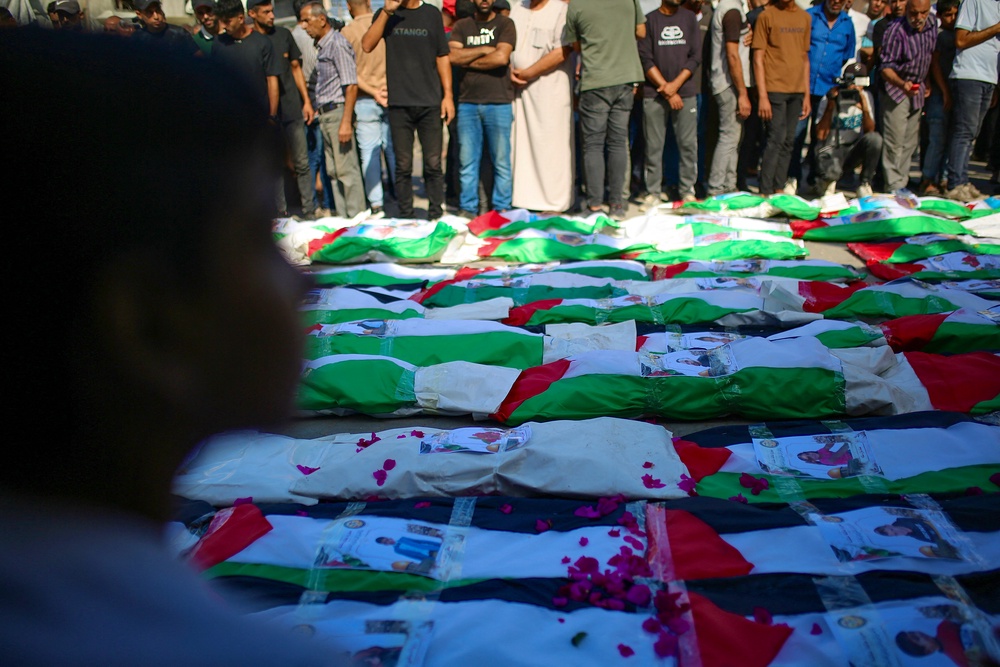 Rows of bodies wrapped in Palestinian flags lie during a funeral ceremony in Zeitoun neighborhood of Gaza City, Gaza (AFP/Getty)