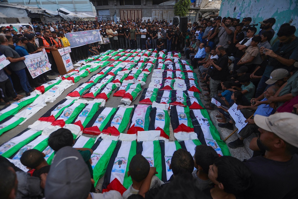 People gather around rows of bodies during a funeral ceremony in Zeitoun neighborhood of Gaza City, Gaza (AFP/Getty)