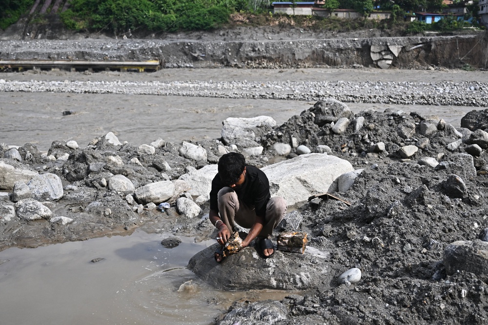 A man tries to recover his belongings in the aftermath of flash floods at Trishuli in Nepal's Nuwakot district on 7 September 2026 (AFP/Getty)