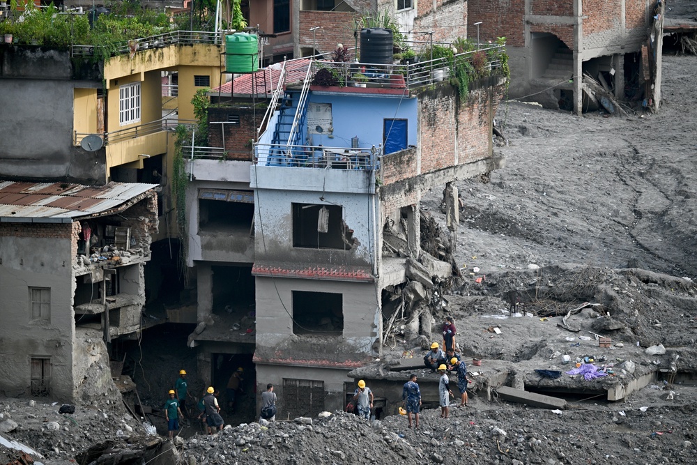 Relief and security personnel inspect a damaged house covered in sludge in the aftermath of flash floods at Trishuli in Nepal's Nuwakot district on 7 September 2026 (AFP/Getty)