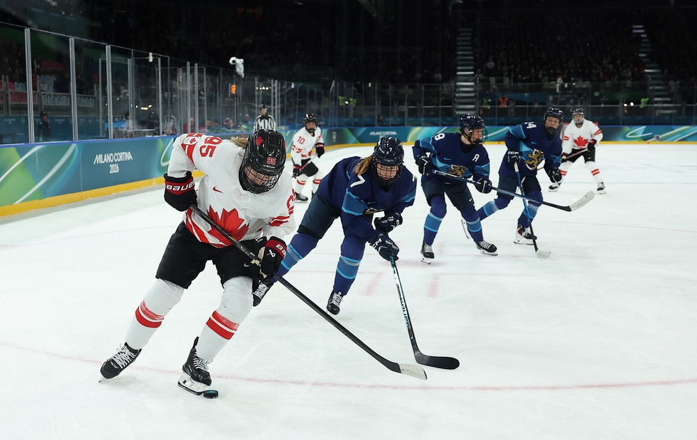 Daryl Watts #95 of Team Canada skates with the puck through a stick check by Sanni Rantala #7 of Team Finland in the third period during the Women's Preliminary Group A match between Finland and Canada on day six of the Milano Cortina 2026 Winter Olympic games at Milano Rho Ice Hockey Arena (Getty)