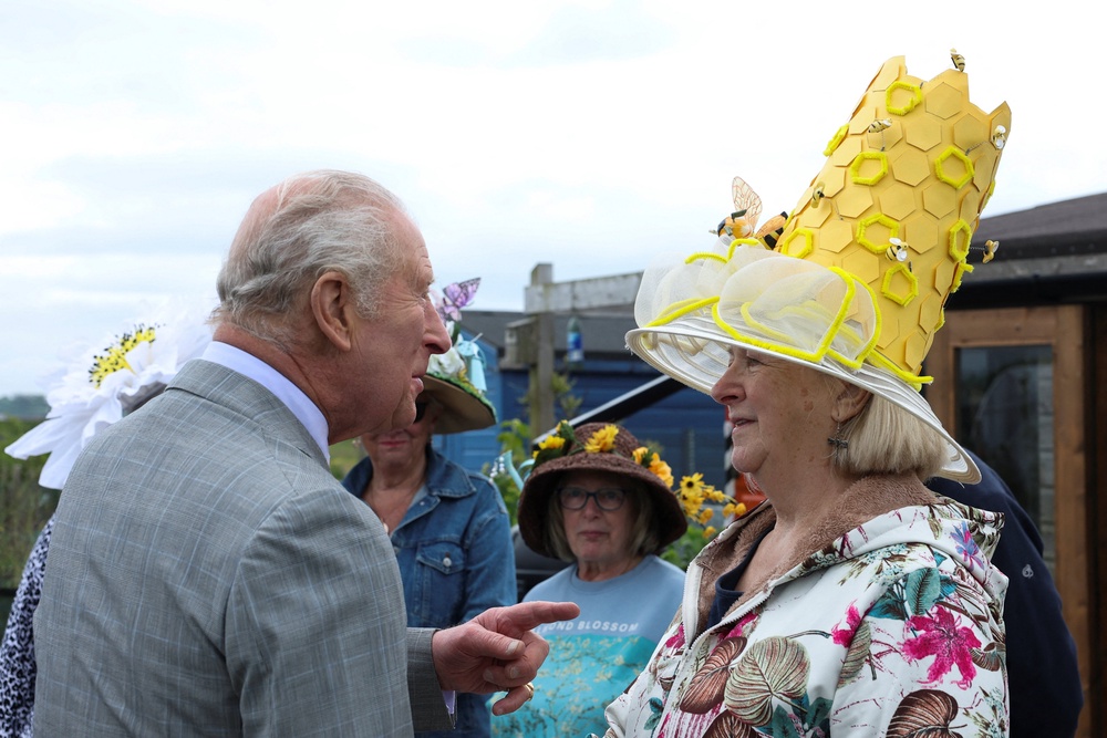 The King meets allotment users dressed in floral design hats while visiting Ards Allotments near Strangford Lough in Northern Ireland in May 2026 (Toby Melville/PA) (PA Wire)
