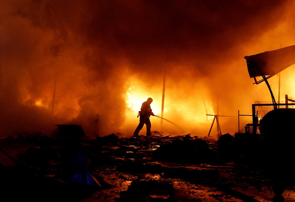 A firefighter works at the site of a private enterprise hit during Russian missile and drone strikes in Kyiv (Reuters)