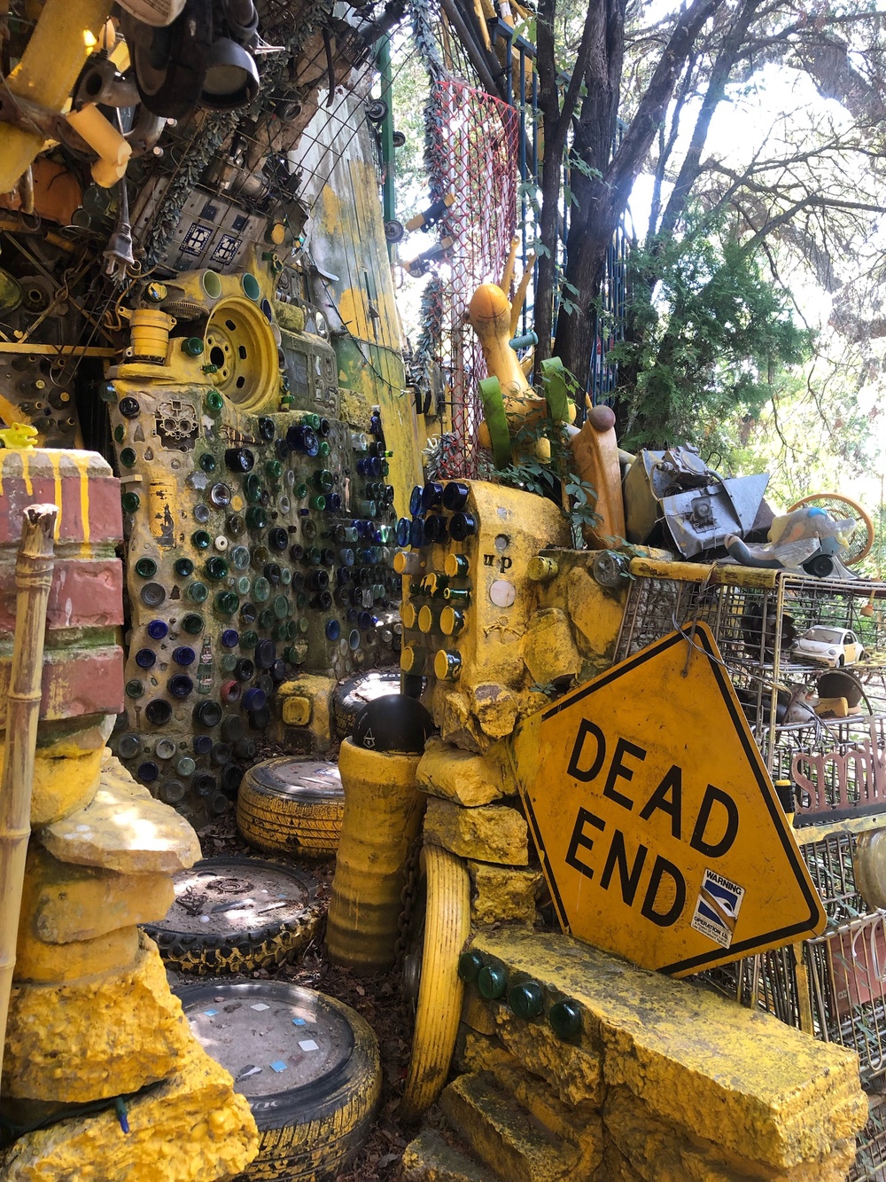 Inside the Cathedral of Junk, dozens of glass bottles poke through the partial cement walls, and light shines through the top of the structure’s frame (Vince Hannemann)