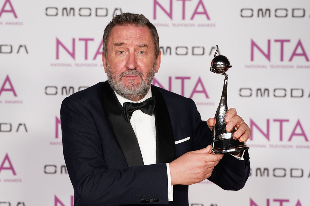 Lee Mack with the quiz show award for The 1% Club (Ian West/PA) (PA Wire)