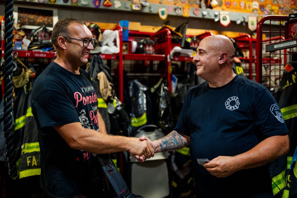 Argano, right, Ladder 10, greets Laurent Cosenefroy, a volunteer firefighter from France visiting New York and the FDNY
