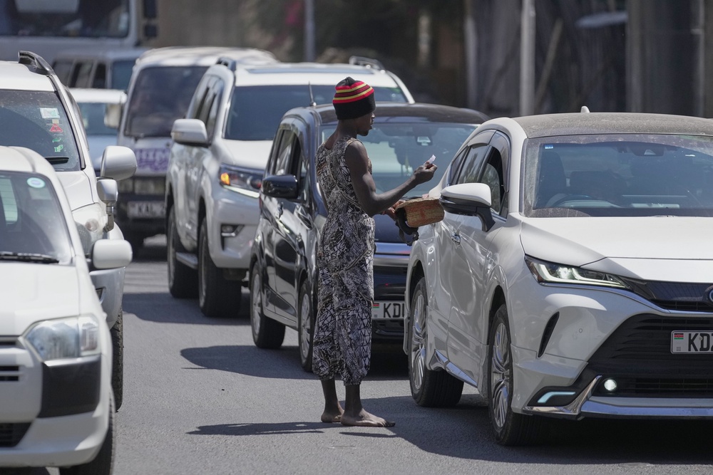 Acrobats collect contributions from motorists after a short performance in a busy street (AP Photo/Brian Inganga)