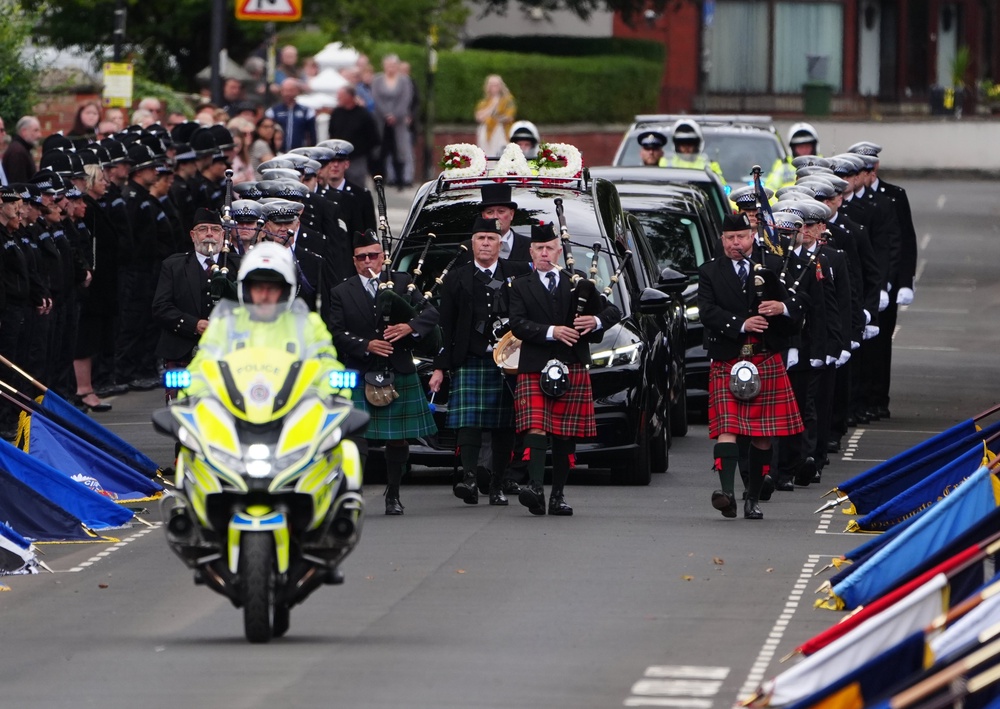 Bagpipers lead the funeral cortege through the streets lined with police colleagues at the ceremonial parade to the funeral of PC Matthew Blades (PA)