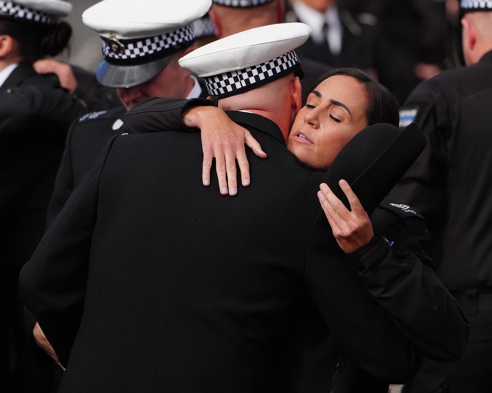 Police officers hug each other before the funeral of PC Matthew Blades. (PA)