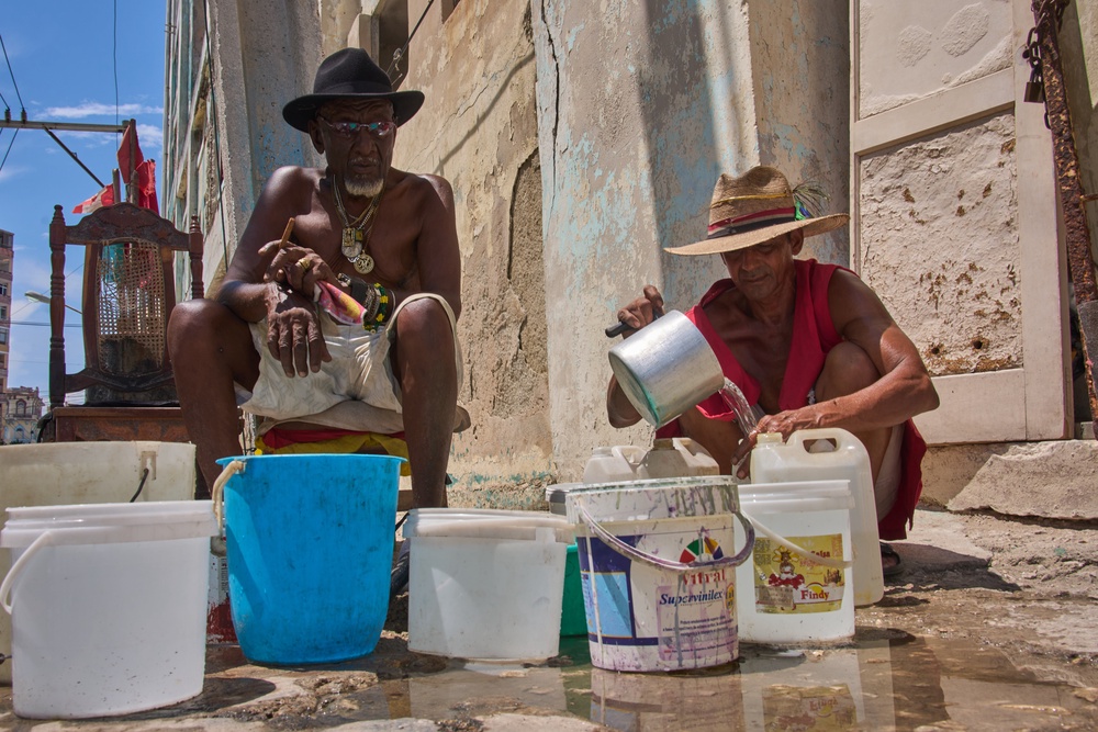 Oscar Joaquín López (left) and his housemate Wilfredo Cisneros Duarte collect water from a street pipe in Havana, Cuba on Sept. 7, 2026 (AP)
