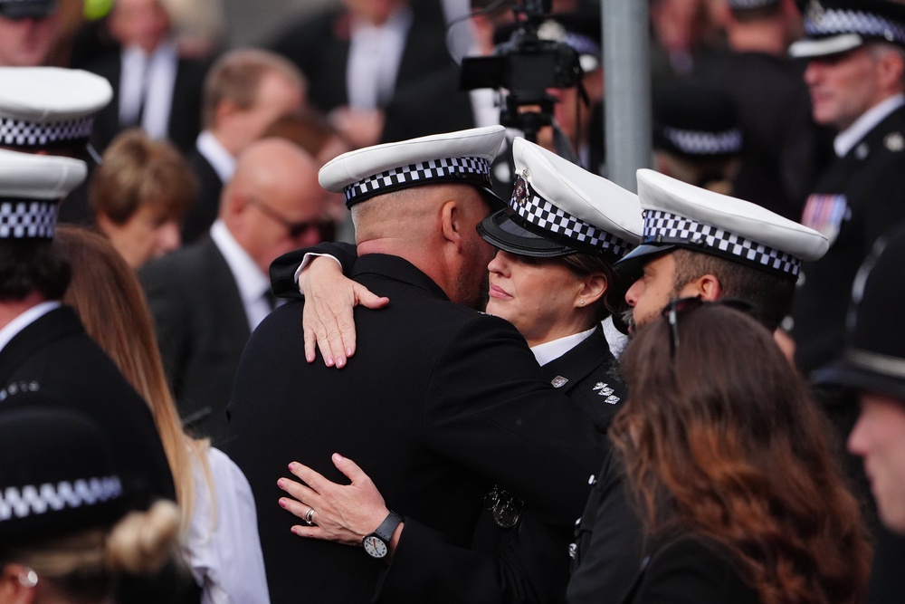 Police officers hug each other before the funeral of Pc Matthew Blades (Owen Humphreys/PA) (PA Wire)
