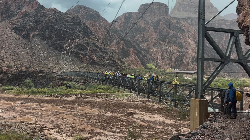 People cross a bridge amid flash flooding in Arizona’s Grand Canyon on August 29. A fast-moving storm forced the rescue of 80 people and killed two men (Reuters)