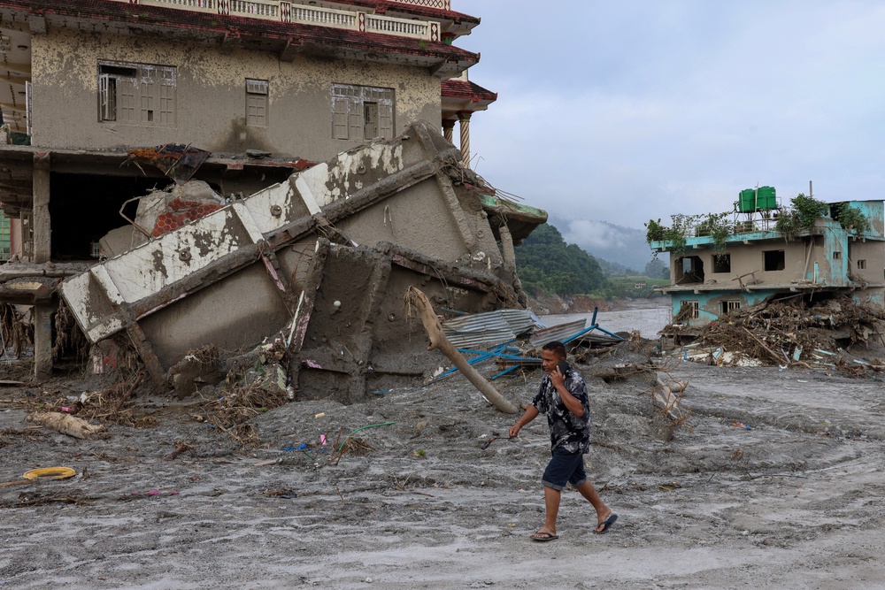 A man walks past damaged houses following deadly flash floods in Devighat, Nuwakot district, Nepal, on 8 September 2026 (Reuters)