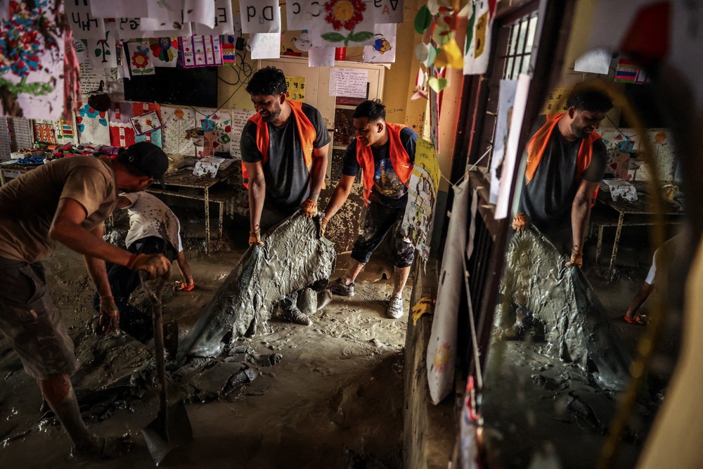 Volunteers remove sludge from a classroom at Shree Bagheswori Madhyamik School in Galchhi, Nepal, on 31 August 2026 (Reuters)
