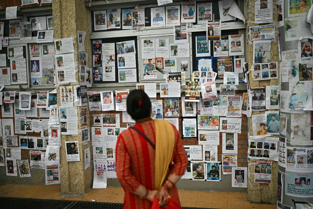 A woman looks at photographs of missing persons outside a morgue in Kathmandu on 9 September 2026 (AFP/Getty)