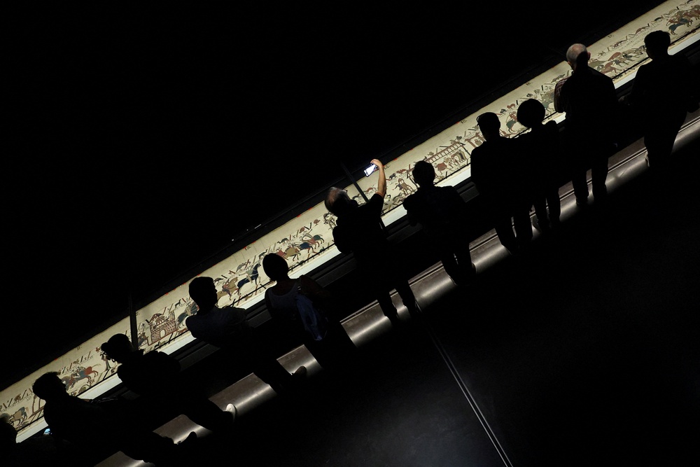 Ticket-holders view the Bayeux Tapestry from a raised platform (REUTERS)