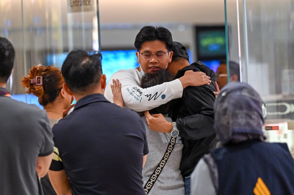 Passengers greet loved ones after landing in Bangkok after the Singapore Airlines flight was diverted after turbulence (AFP/Getty)