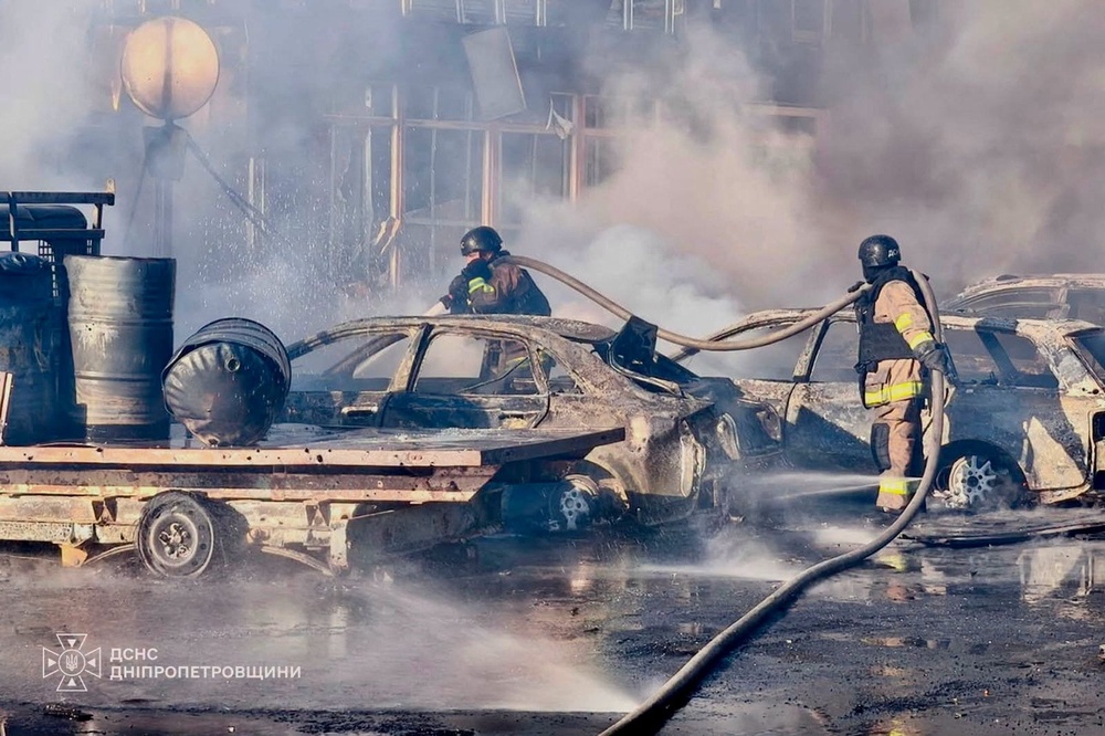 Firefighters work at the site of shops and a market hit by a Russian drone strike in the city of Pavlohrad (Reuters)
