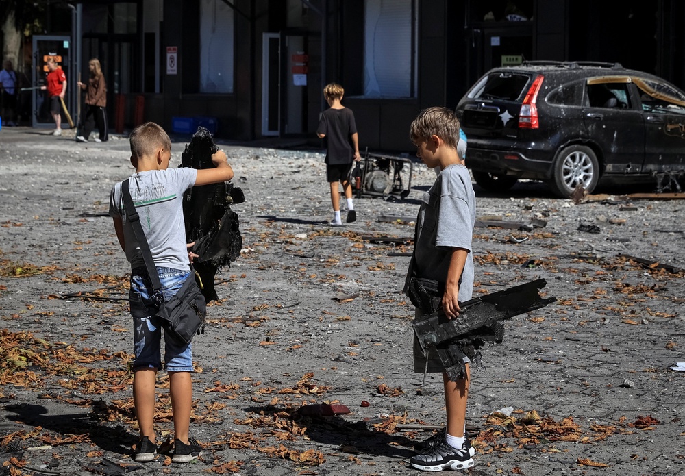 Children hold parts of a Russian drone near a hotel damaged during a Russian drone strike, amid Russia's attack on Ukraine, in the city of Chornomorsk, Odesa  region (Reuters)
