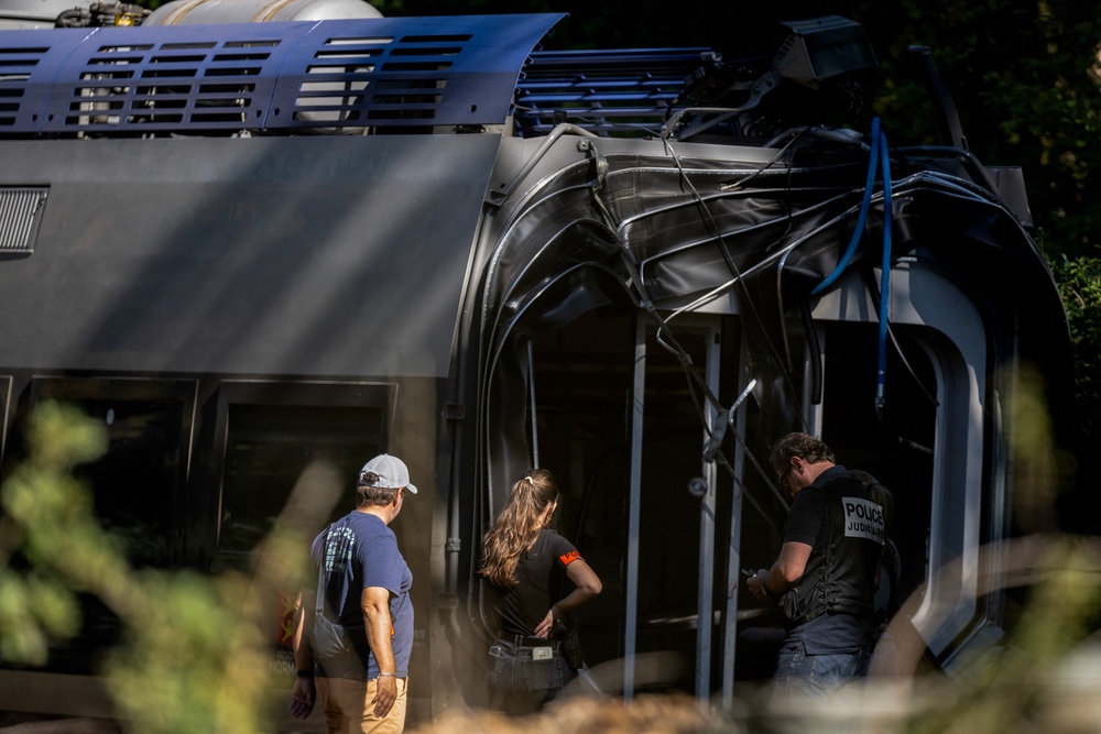 Police officers investigate on the site, after a train derailed yesterday evening while carrying 186 passengers, injuring 44 people, one of them seriously, in Cleon, northwestern France (AFP/Getty)
