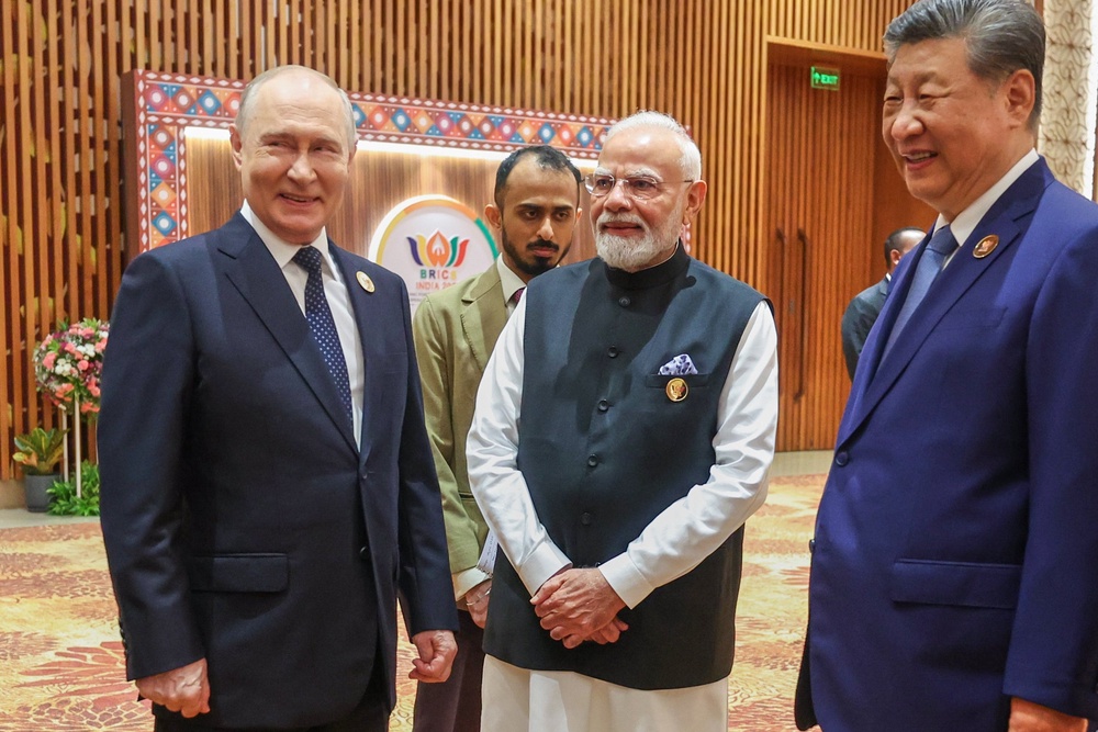 Narendra Modi, center, reacts with Russian President Vladimir Putin, left, and Chinese President Xi Jinping during the BRICS summit (AP)