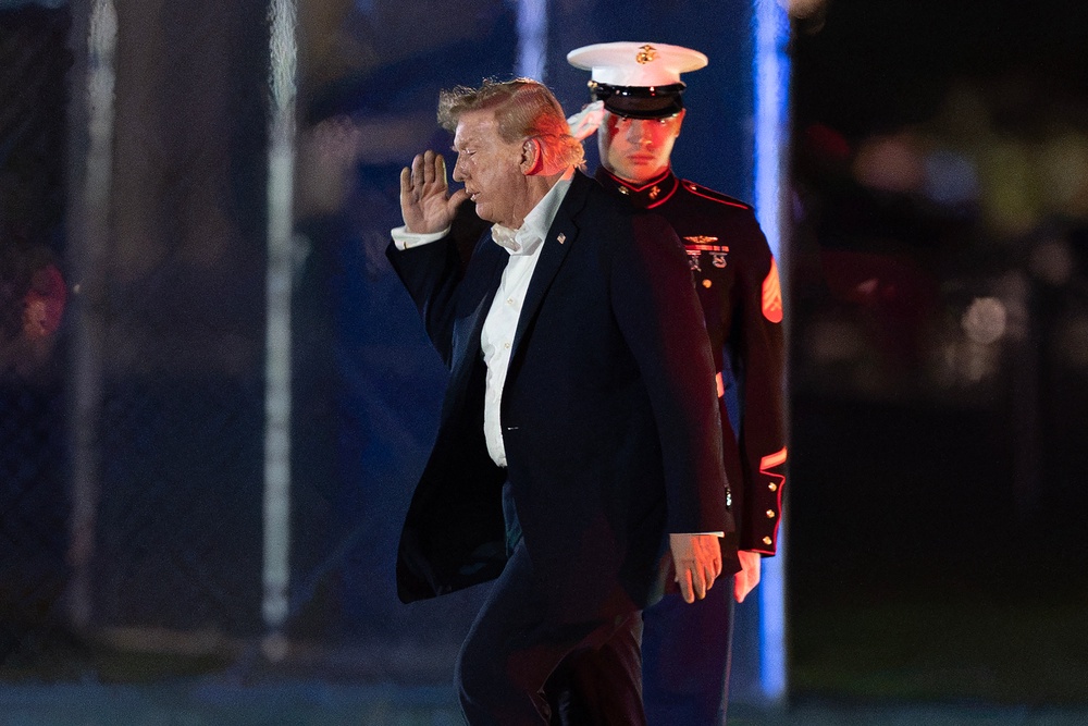 President Donald Trump returns a salute as he walks from Marine One to his limousine upon his arrival at the Ellipse just outside of the White House (AP)
