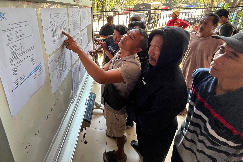 People check the passenger manifest of Virgo Transport 8 passenger ferry which overturned in bad weather in the Java Sea, at the rescuers' command center in Banjarmasin, South Kalimantan, Indonesia, Monday, 14 Sept 2026 (AP)