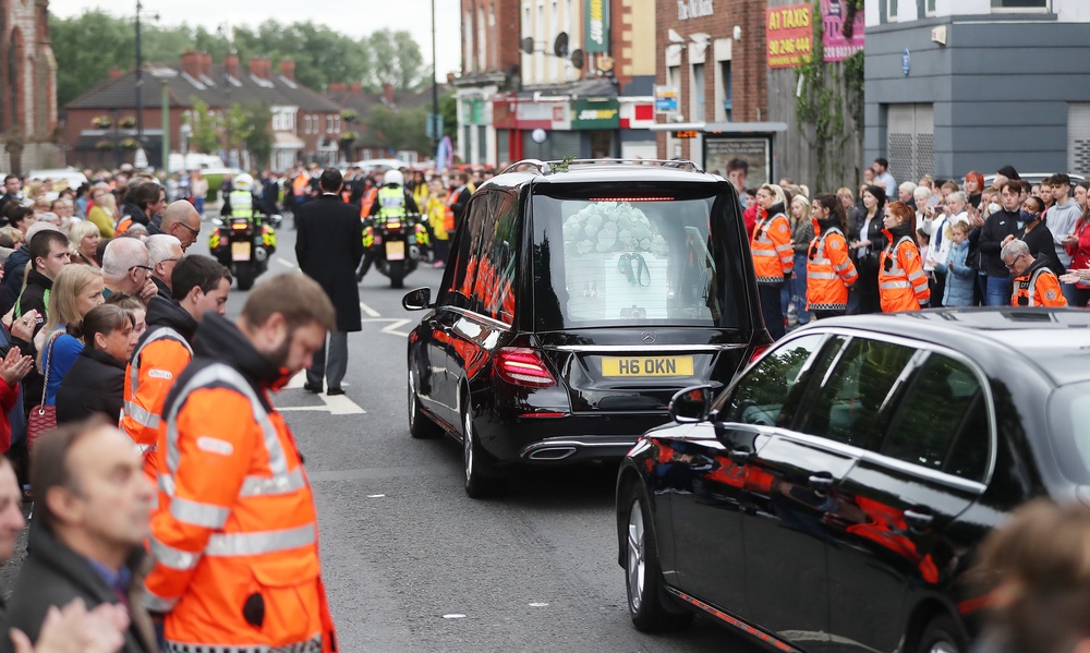 Members of the Community Rescue Service form a guard of honour as the funeral cortege of 14-year-old Noah Donohoe leaves St Malachy’s college in Belfast (Niall Carson/PA) (PA Archive)