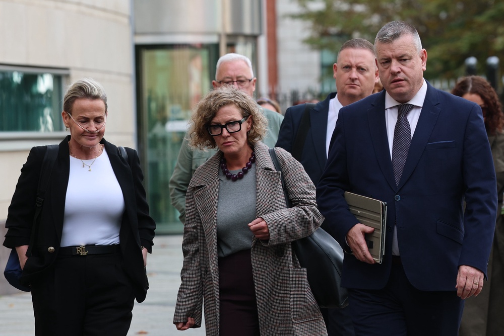 Fiona Donohoe (centre), with her sister Shona Donohoe (left) and family solicitor Niall Murphy (right) outside Belfast Coroner’s Court (Liam McBurney/PA) (PA Wire)