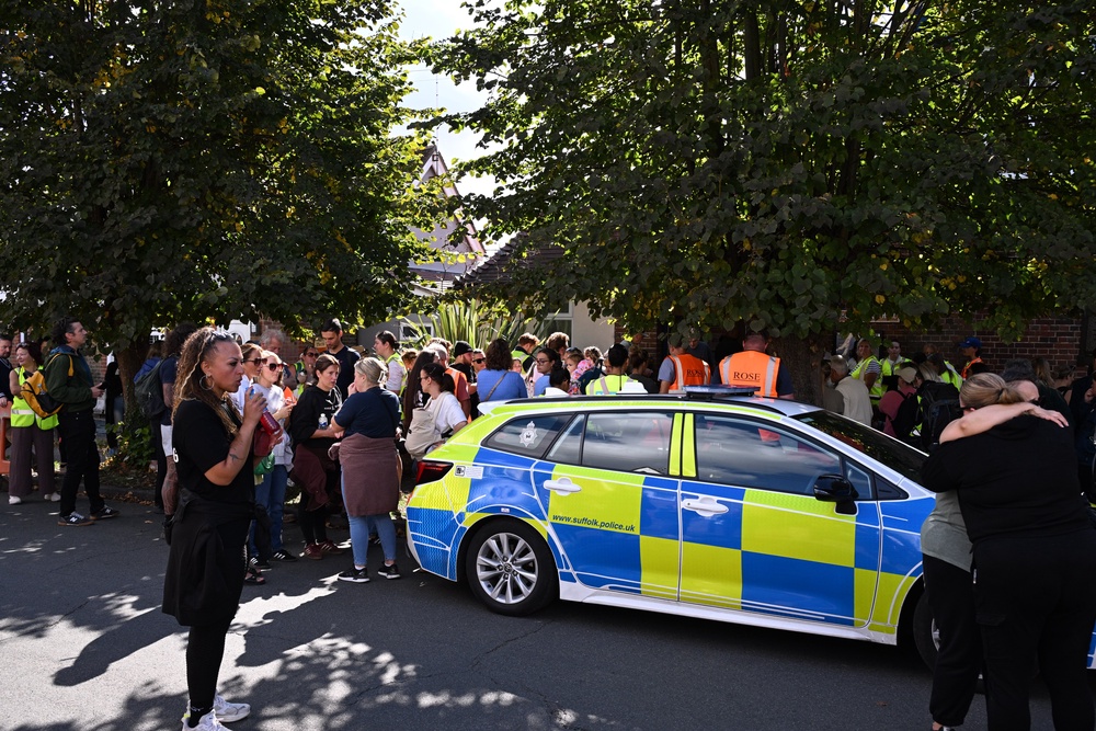 Local residents wait outside Brantham Village Hall (PA)