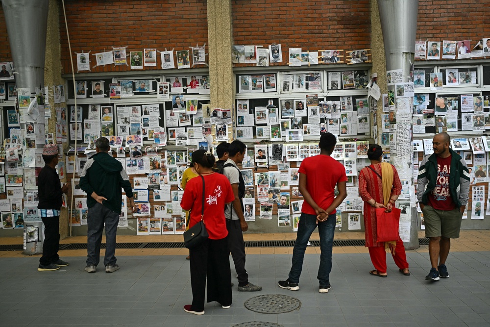 People look at photographs of missing persons outside a morgue in the aftermath of flash floods in Kathmandu (AFP/Getty)
